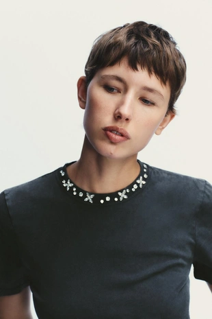 Футболка с эффектом потертости и отделкой драгоценностями- Заказать в России