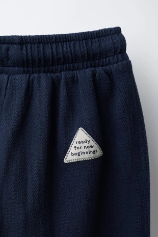 Брюки с текстурным рисунком и нашивкой