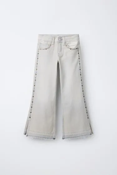 Джинсы с зауженной брючиной и заклепками- Заказать в России