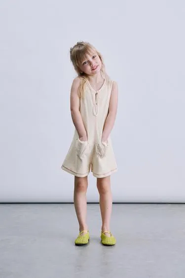 Короткий комбинезон из махровой ткани с карманами-ракушками