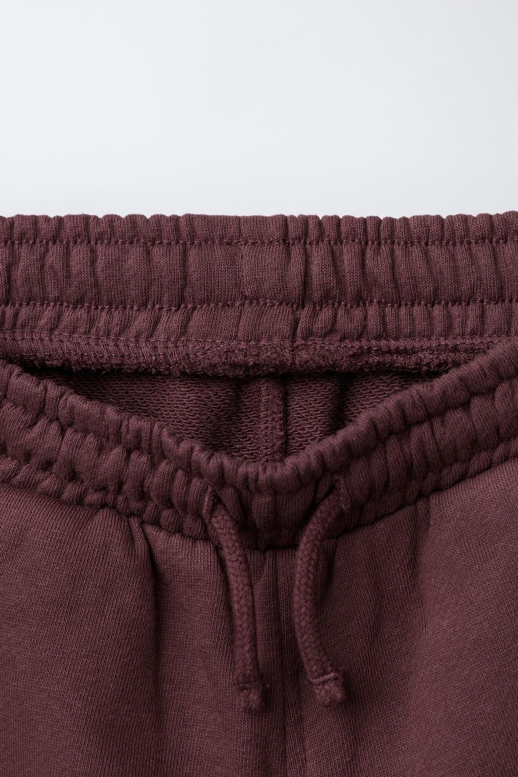 БРЮКИ-ДЖОГГЕРЫ ИЗ МЯГКОЙ ТКАНИ С ЭТИКЕТКОЙ