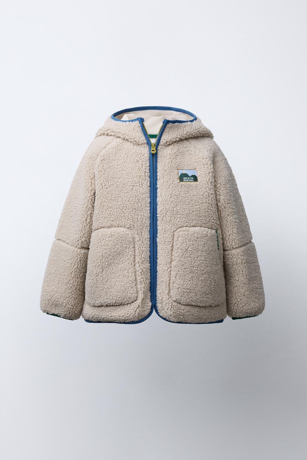 КУРТКА ИЗ ИСКУССТВЕННОЙ ОВЧИНЫ С КАПЮШОНОМ И КОНТРАСТНЫМИ ДЕТАЛЯМИ