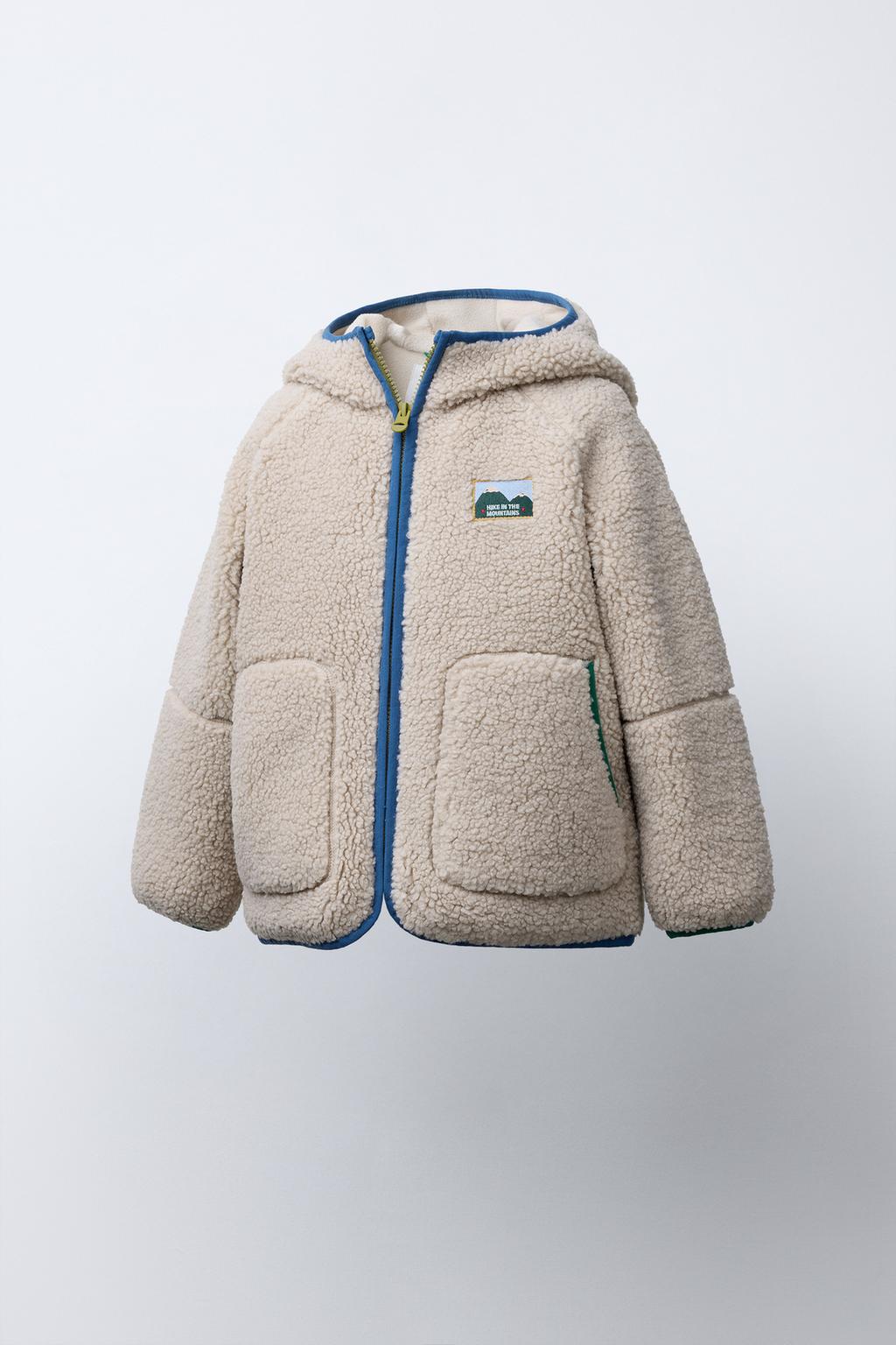 КУРТКА ИЗ ИСКУССТВЕННОЙ ОВЧИНЫ С КАПЮШОНОМ И КОНТРАСТНЫМИ ДЕТАЛЯМИ