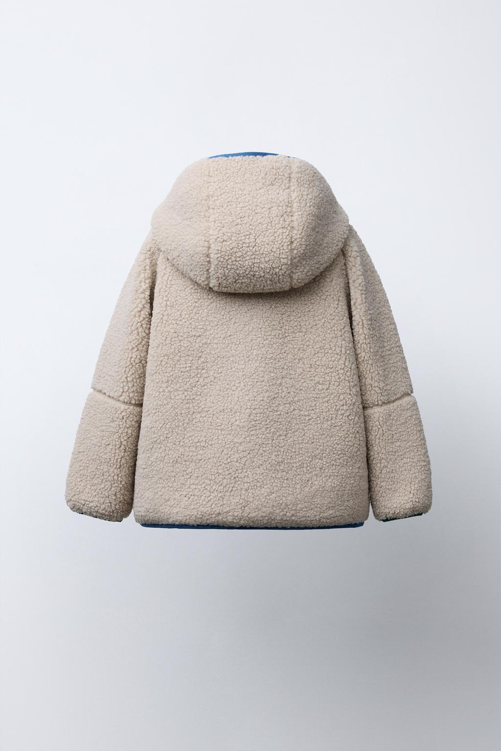 КУРТКА ИЗ ИСКУССТВЕННОЙ ОВЧИНЫ С КАПЮШОНОМ И КОНТРАСТНЫМИ ДЕТАЛЯМИ