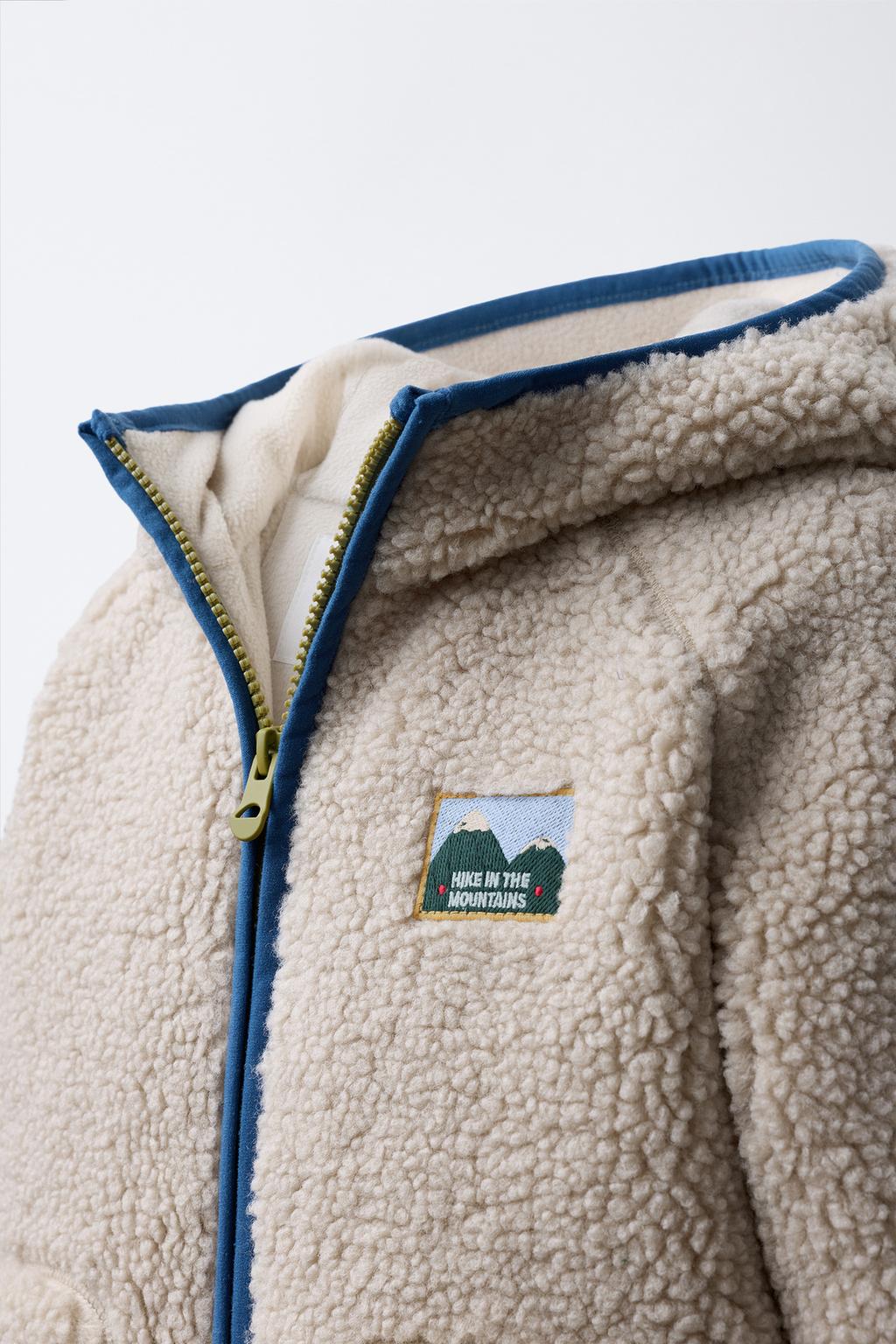 КУРТКА ИЗ ИСКУССТВЕННОЙ ОВЧИНЫ С КАПЮШОНОМ И КОНТРАСТНЫМИ ДЕТАЛЯМИ