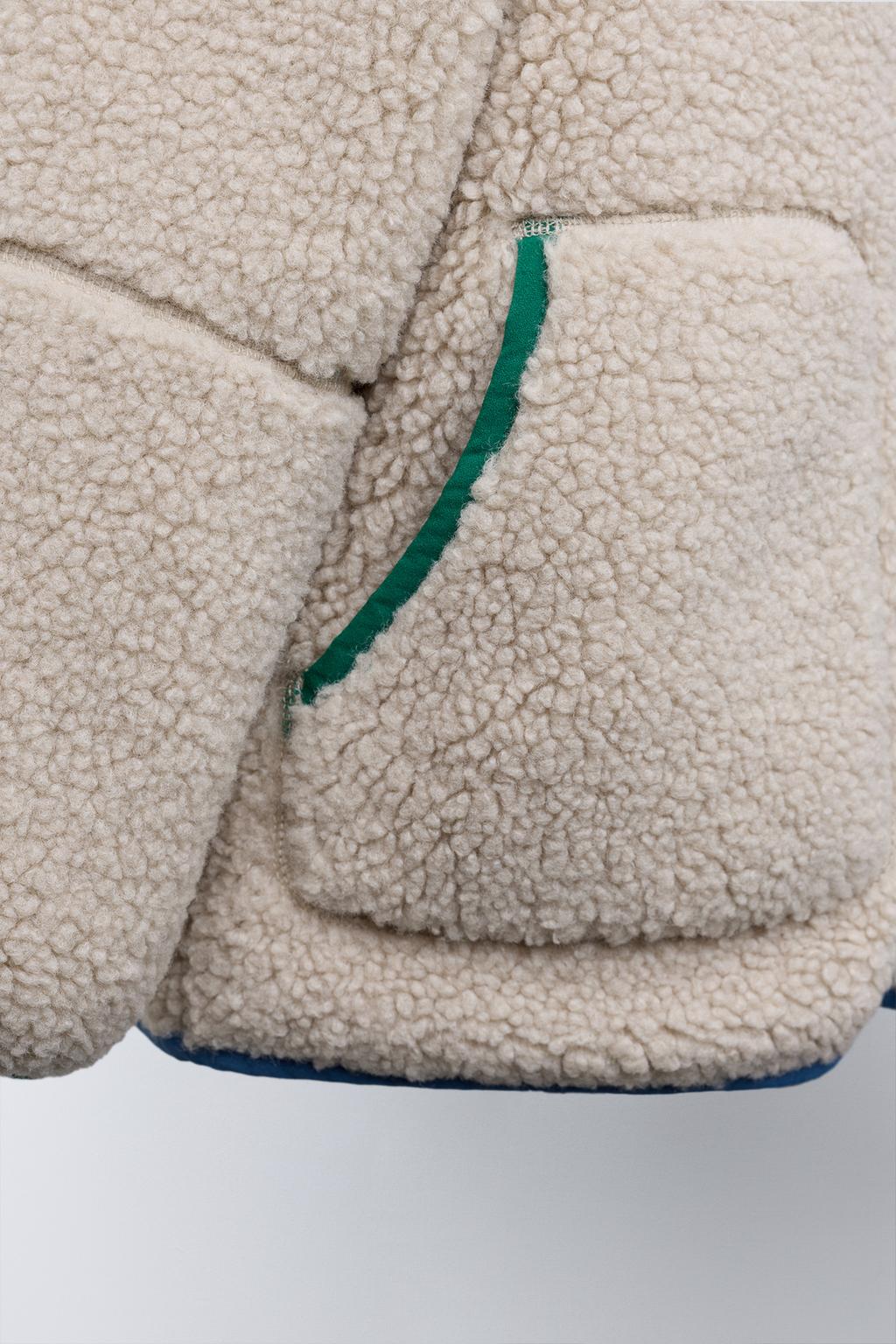 КУРТКА ИЗ ИСКУССТВЕННОЙ ОВЧИНЫ С КАПЮШОНОМ И КОНТРАСТНЫМИ ДЕТАЛЯМИ