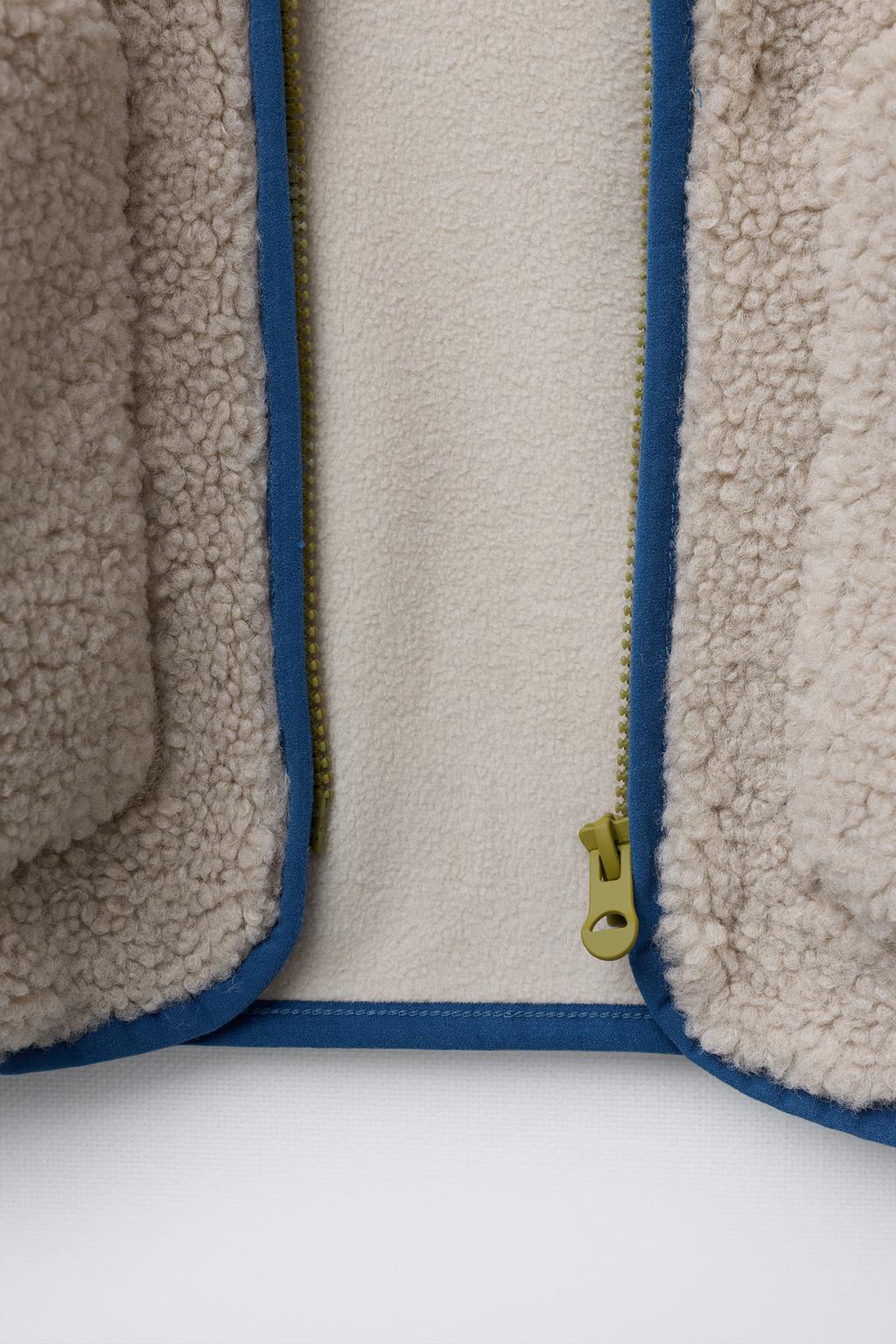 КУРТКА ИЗ ИСКУССТВЕННОЙ ОВЧИНЫ С КАПЮШОНОМ И КОНТРАСТНЫМИ ДЕТАЛЯМИ