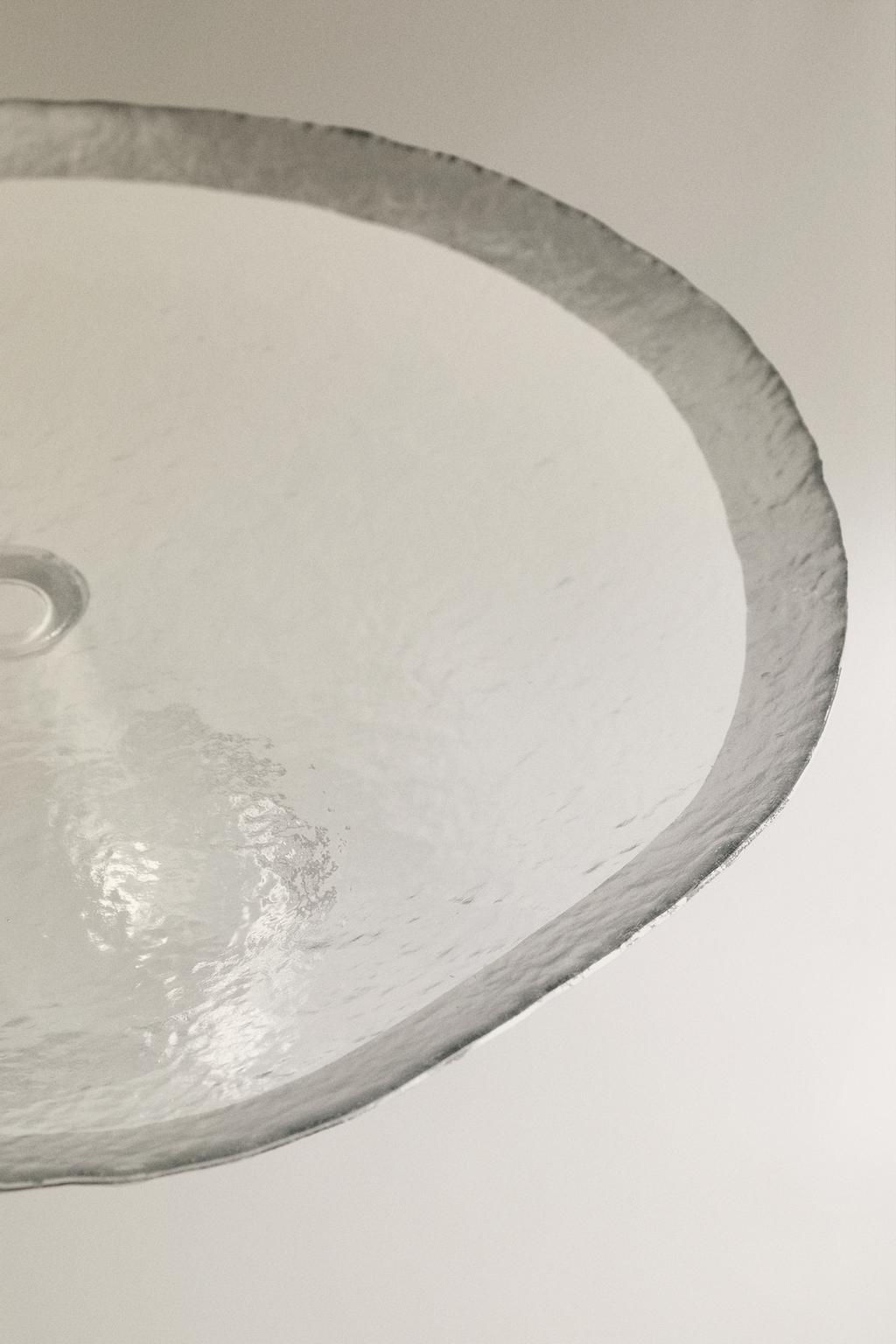 Поднесенное стеклянное блюдо с серебристым ободом