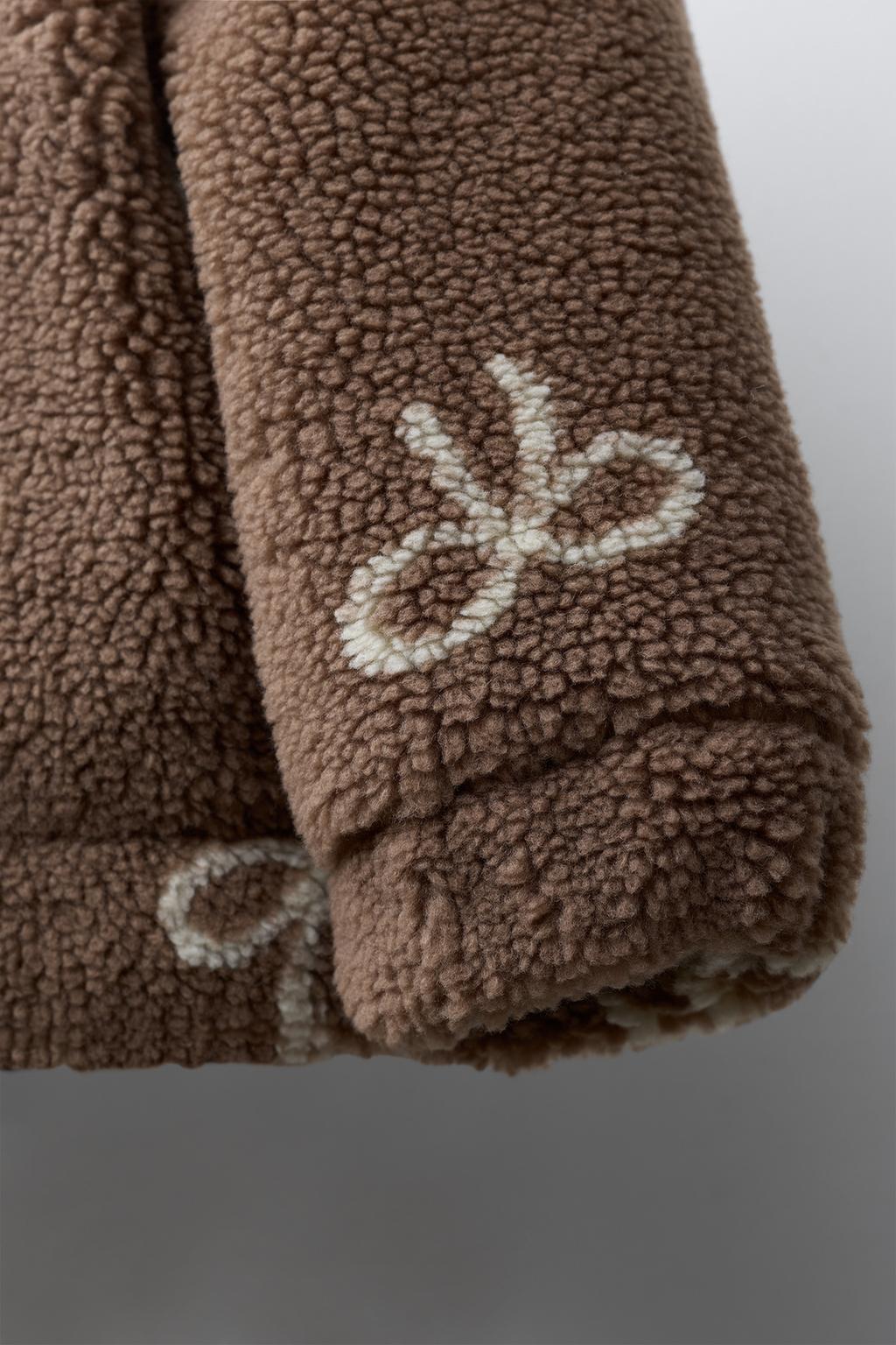 КУРТКА ИЗ ИСКУССТВЕННОЙ ОВЧИНЫ С БАНТАМИ