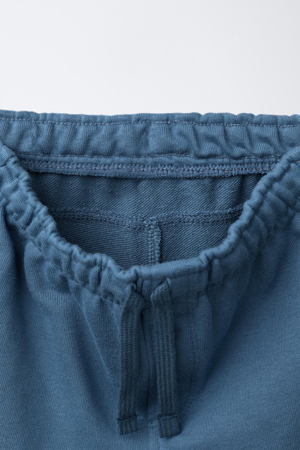 ШОРТЫ ИЗ МЯГКОЙ ТКАНИ ПРЯМОГО КРОЯ С РЕЛЬЕФНОЙ НАДПИСЬЮ