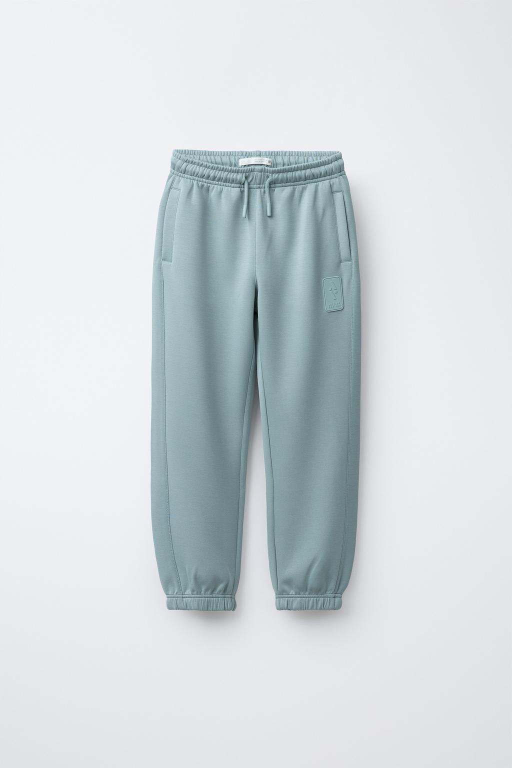 СПОРТИВНЫЕ БРЮКИ-ДЖОГГЕРЫ С ПРОРЕЗИНЕННОЙ НАШИВКОЙ