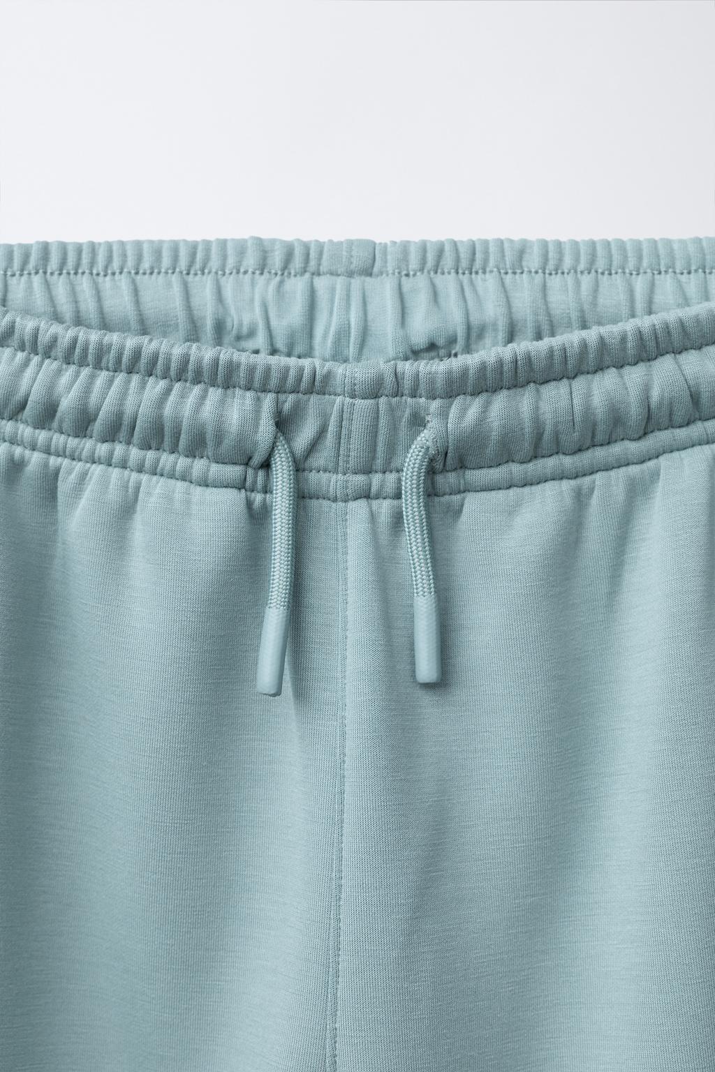 СПОРТИВНЫЕ БРЮКИ-ДЖОГГЕРЫ С ПРОРЕЗИНЕННОЙ НАШИВКОЙ