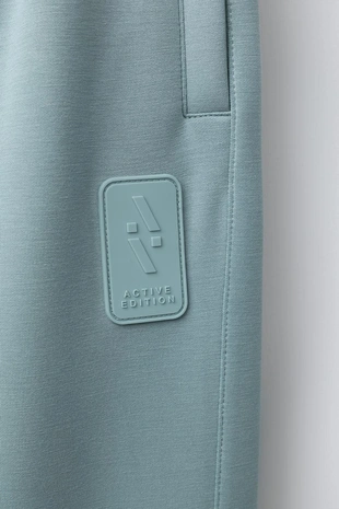 Спортивные брюки-джоггеры с прорезиненной нашивкой- Заказать в России