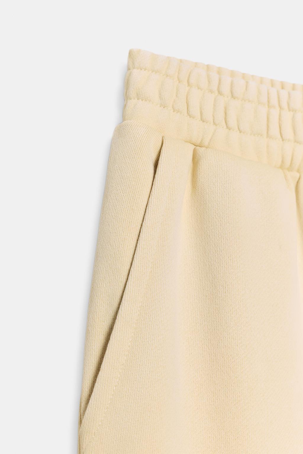 БРЮКИ ИЗ МЯГКОЙ ТКАНИ С ЭФФЕКТОМ ПОТЕРТОСТИ И ЗАКЛЕПКАМИ