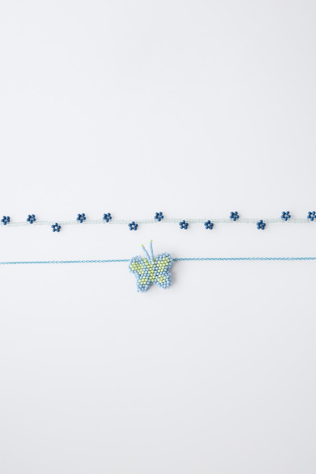 НАБОР ИЗ ДВУХ ОЖЕРЕЛИЙ С БУСИНАМИ, БАБОЧКОЙ И ЦВЕТАМИ