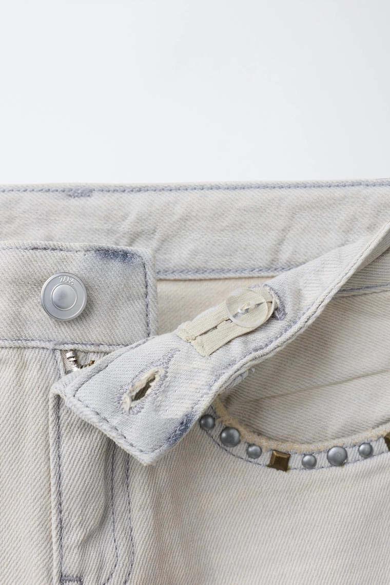 Джинсы с зауженной брючиной и заклепками