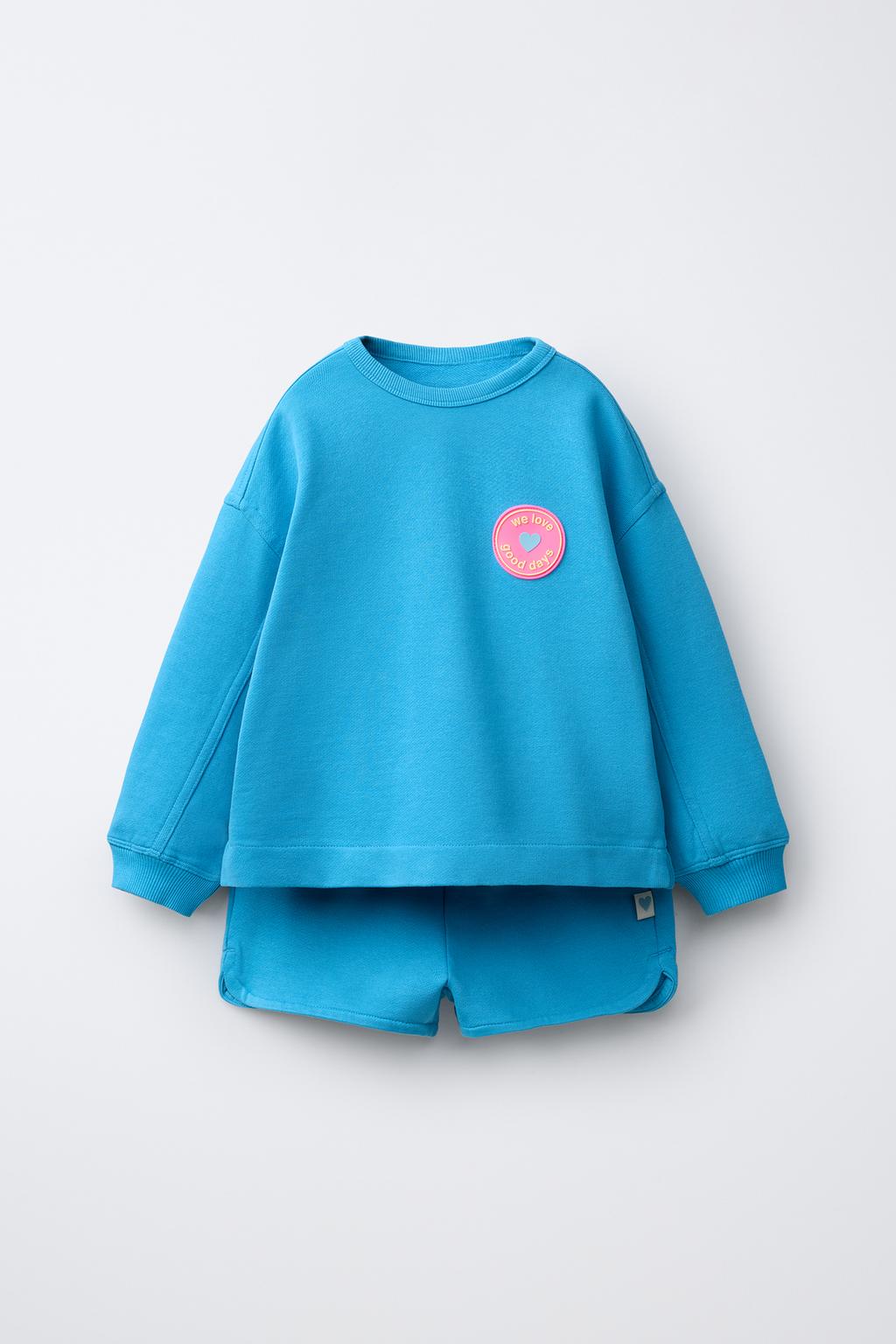 КОМПЛЕКТ ИЗ ТОЛСТОВКИ И ШОРТ С РЕЗИНОВЫМ ЦВЕТКОМ