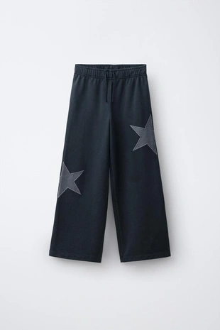 Брюки из мягкой ткани  с эффектом потертости и звездами- Заказать в России