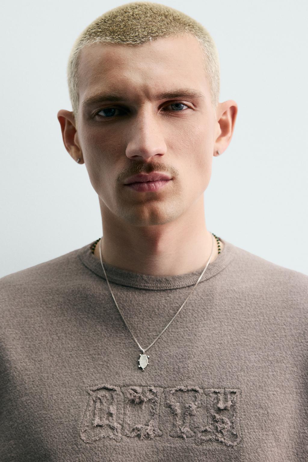 ФУТБОЛКА ИЗ ТКАНИ С ЭФФЕКТОМ ПОТЕРТОСТИ С НАШИВКАМИ