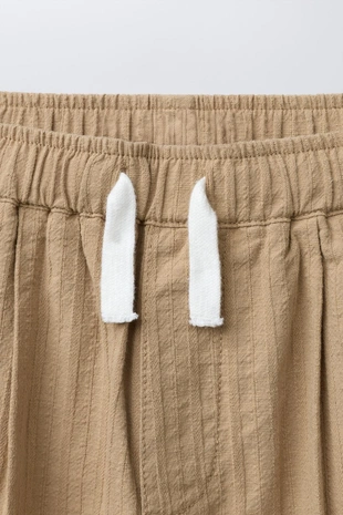 Брюки прямого кроя с защипами и рельефной тканью- Заказать в России