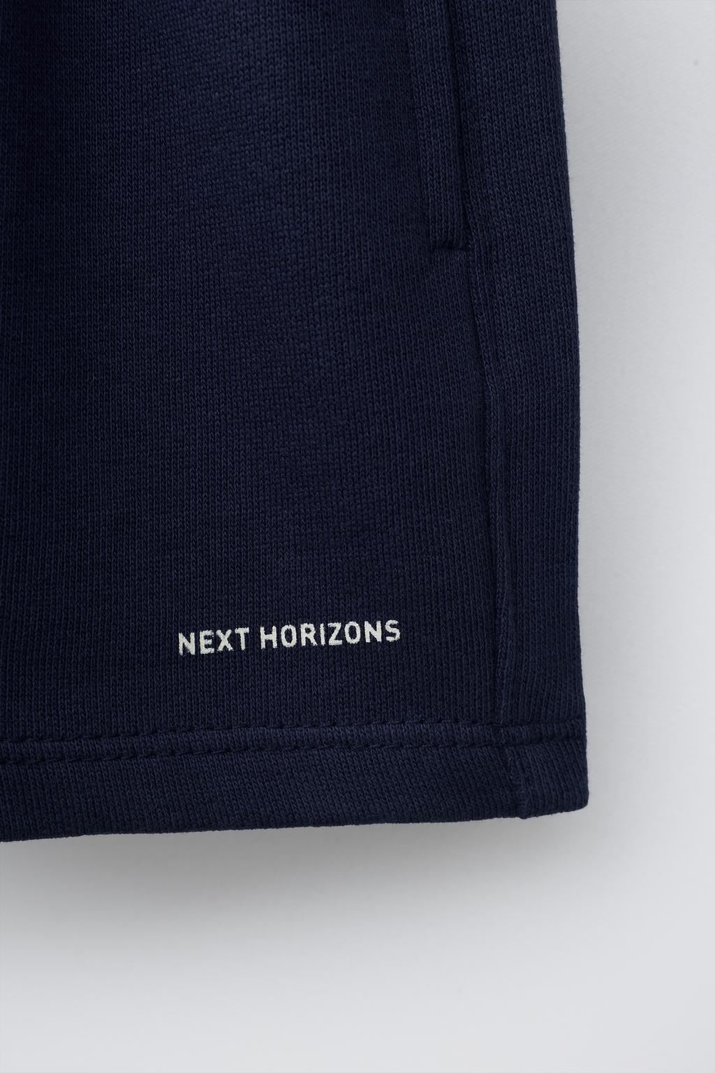 ШОРТЫ-БЕРМУДЫ БАЗОВЫЕ С ТЕКСТОВЫМ ПРИНТОМ